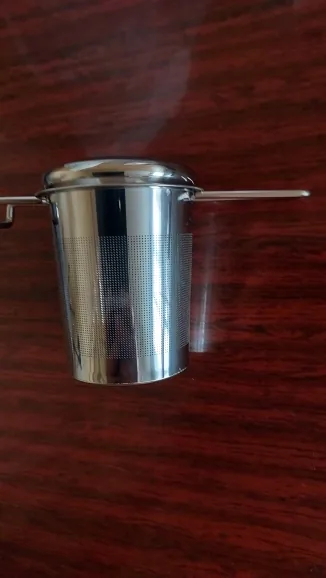 The steel infuser basket seen from the front on a dark red wooden table. Photographed by С***а, a verified buyer